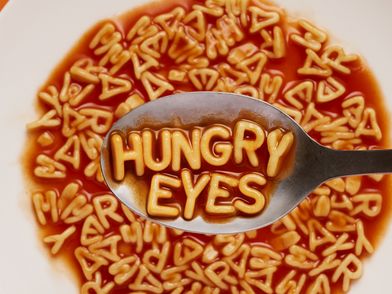 Ein Teller Buchstabensuppe, auf einem Löffel liegen die Buchstaben HUNGRY EYES