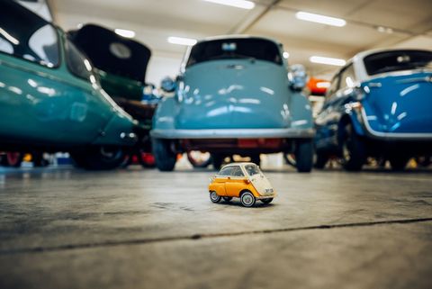 Kleines Modellfahrzeug vor echtem Original