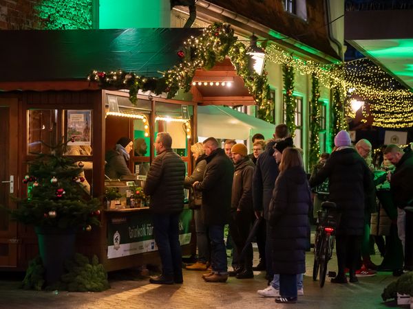 Menschen stehen in der Schlange an einer Bude mit Grünkohl