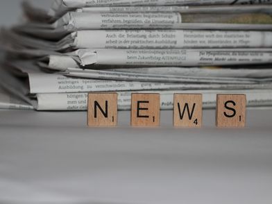 Zeitungsstapel mit Scrabble-Steinen auf denen "News" steht