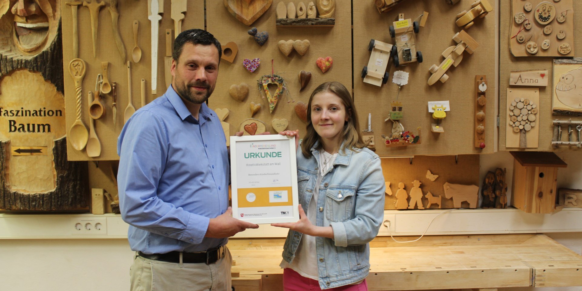 Sören Fehse, Leiter der Kreativwerkstatt am Wall in Nienburg und Michelle Rischkopf von der Mittelweser-Touristik GmbH freuen sich über die Kinderferienland-Auszeichnung., © Mittelweser-Touristik GmbH