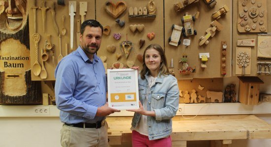 Sören Fehse, Leiter der Kreativwerkstatt am Wall in Nienburg und Michelle Rischkopf von der Mittelweser-Touristik GmbH freuen sich über die Kinderferienland-Auszeichnung., © Mittelweser-Touristik GmbH