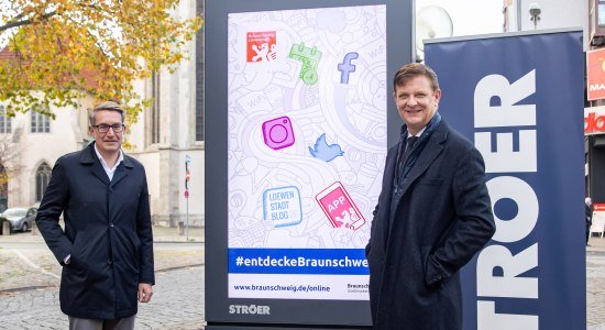 Gerold Leppa, Geschäftsführer des Stadtmarketings, und Harald Rotter, Ströer-Niederlassungsleiter Braunschweig, präsentieren einen der neuen Cityscreens am Standort Ecke Schild/Meinhardshof in Braunschweig., © Braunschweig Stadtmarketing GmbH/Philipp Ziebart