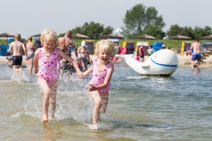 Kinder spielen am Strand